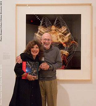 gail buckland holding the who shot sports book standing with howard schatz in front of his photograph
